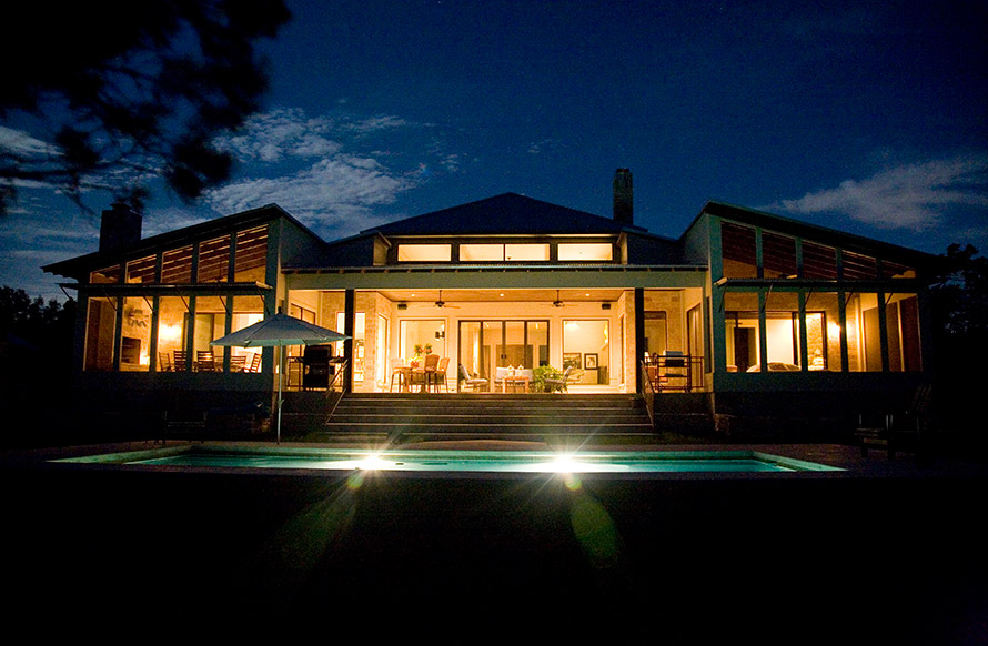 Large pool on the back of the house at night.