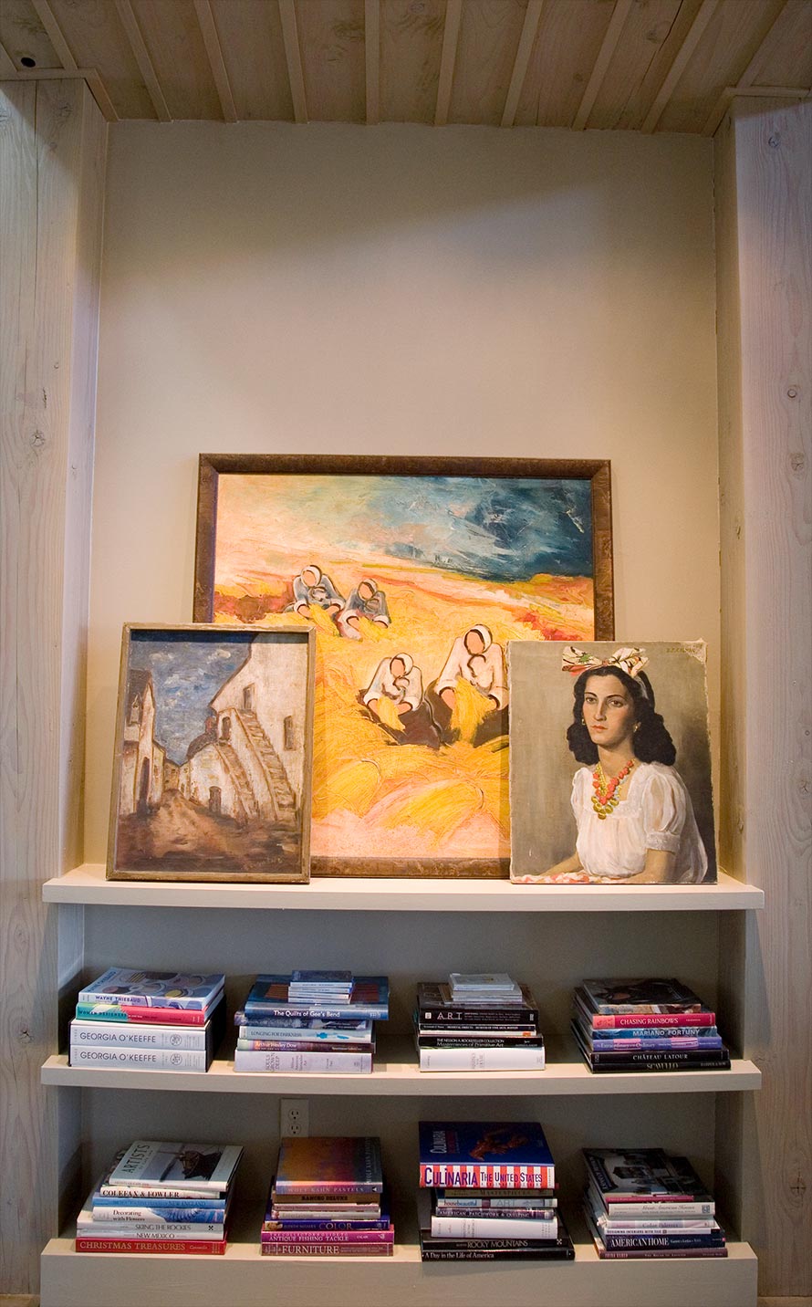 Book shelf with three paintings.
